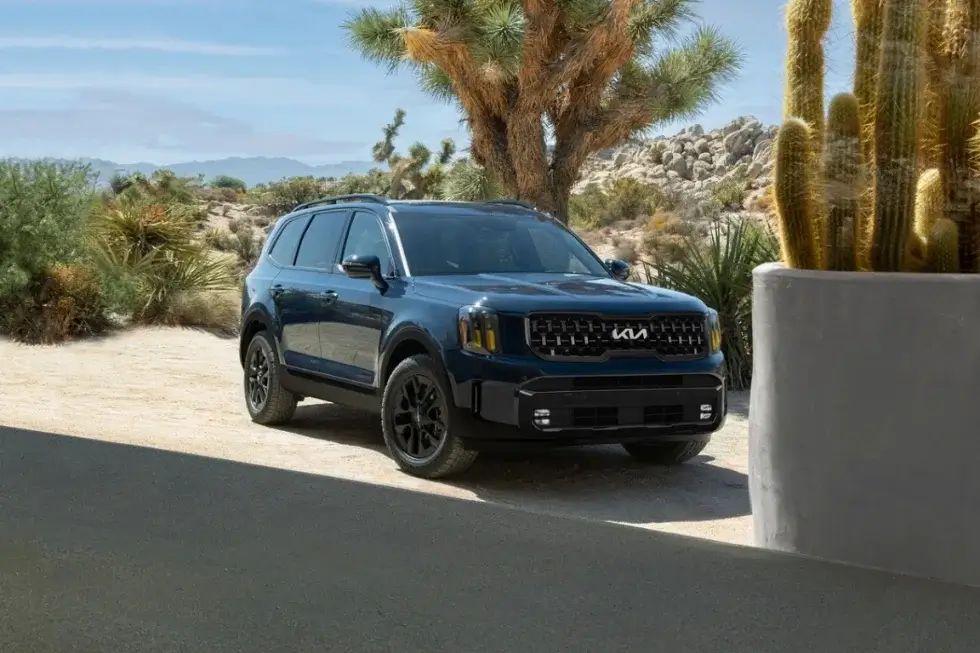 Kia Telluride SUV parked next to a cactus The Telluride is a large SUV that offers optional bench seating for the second row making it a great choice for families