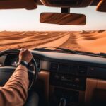 Car driving through the desert in Dubai, showcasing how to protect your vehicle in harsh climates.