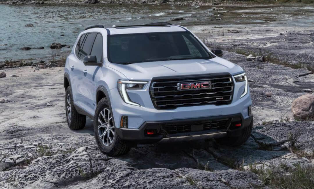 2025 GMC Acadia AT4 front view parked on rocky terrain