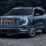 Front view of the 2025 GMC Acadia SUV in a dark metallic finish
