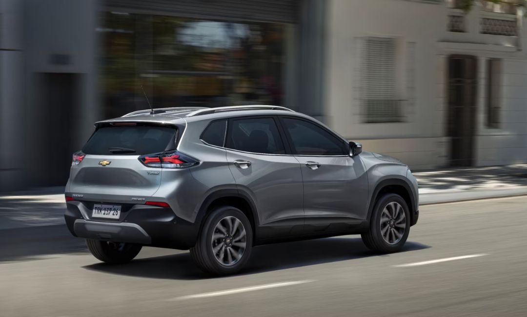 Rear 34 view of the 2026 Chevy Tracker driving on a city street in Brazil