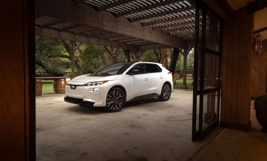 Front-side view of the 2026 Subaru Solterra EV parked outdoors under a wooden pergola