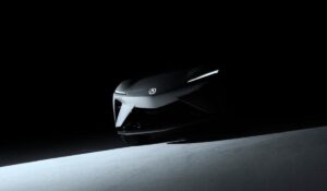 Shadowy teaser image of the Acura RSX Prototype EV front view, showing sharp headlights and Acura emblem.