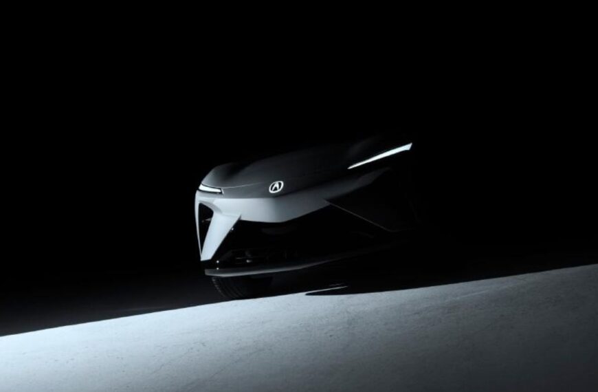 Shadowy teaser image of the Acura RSX Prototype EV front view, showing sharp headlights and Acura emblem.