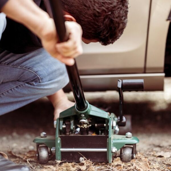 a man repairing a truck with a tool