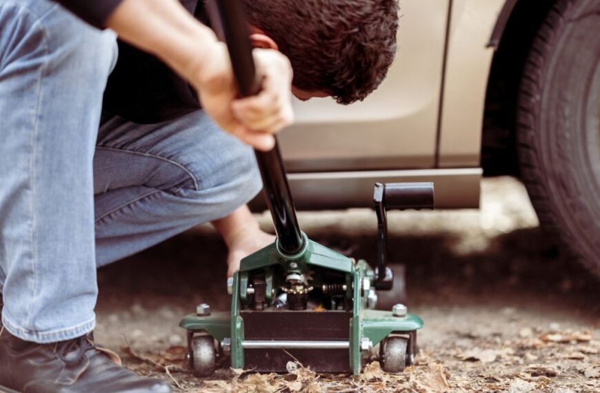 a man repairing a truck with a tool